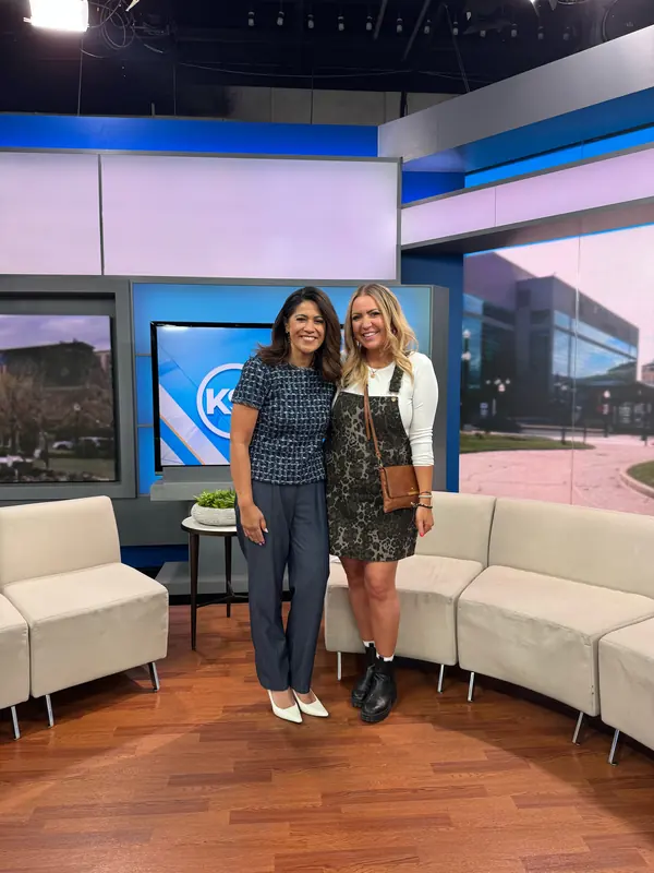 Dani standing with a TV host on a morning news set.