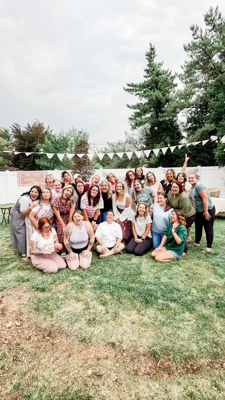 A big group of Bestie Squad women at a backyard party under string lights.